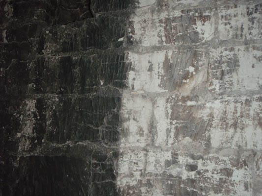 aug 2 009 - Greenleaf Contractors | Sandblasting And Pressure Washing | UK Brick wall showing contrast between heavily soiled dark section and partially cleaned lighter area
