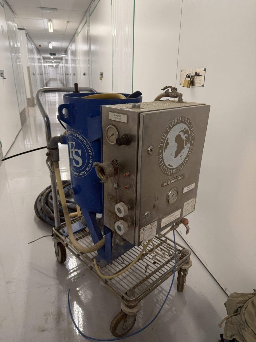 The Farrow System wet blasting unit on wheeled trolley in corridor of commercial facility